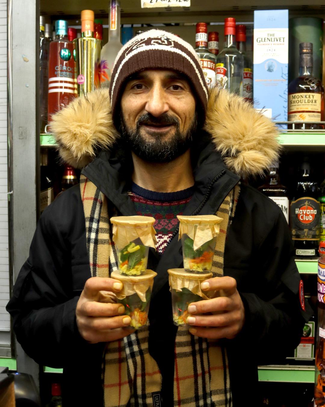 Abdul holding cups of his homemade tea